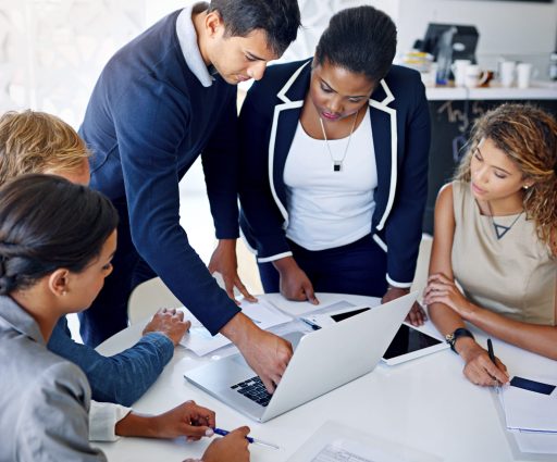 Team brainstorming. Shot of a group of coworkers working together on a laptop in an office